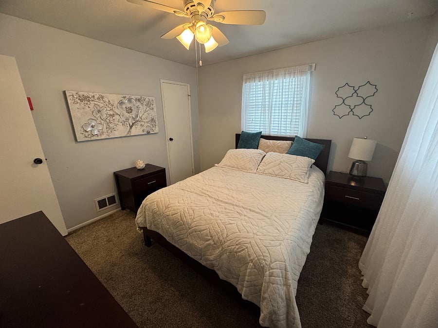 Master bedroom queen bed with carpet.