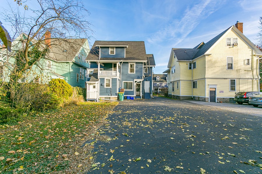 Covered private entrance on left of rear of house (leads to 3rd floor apartment). Private parking lot in rear of building with one space available for this rental