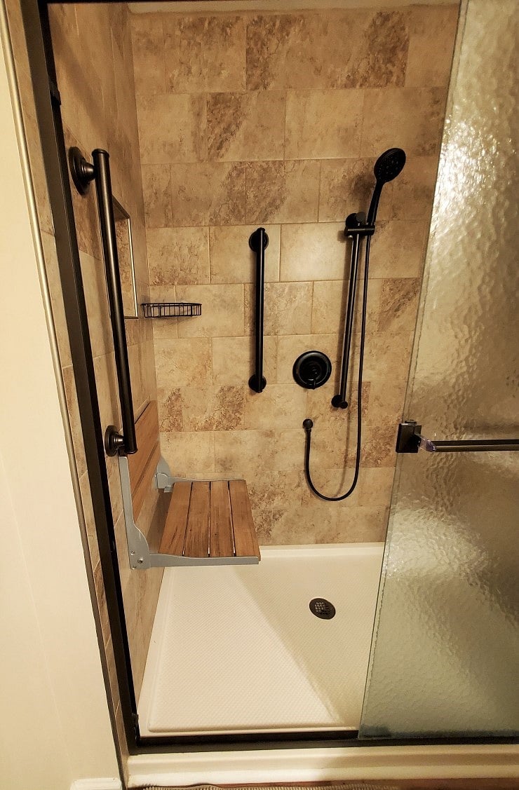 Shower with teak fold-down bench, grab bars and hand-held shower