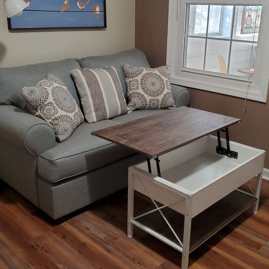 Coffee table lifts for a higher surface for eating or working.