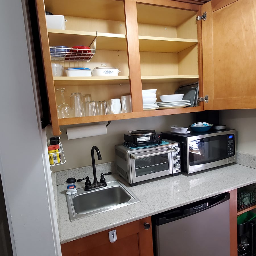 Kitchenette showing dishes and cooking implements