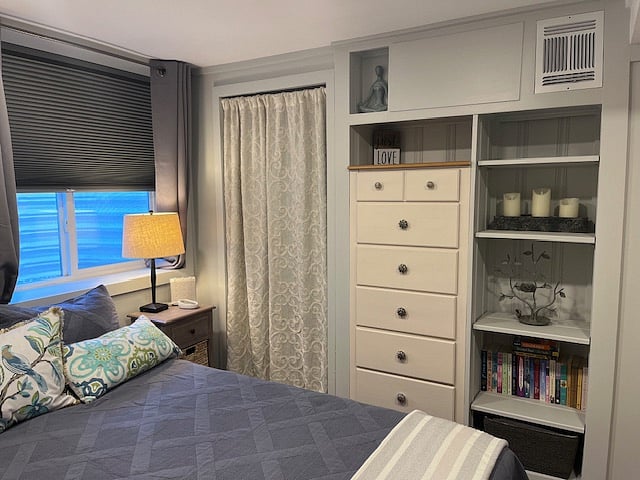 Bedroom with room darkening shades and curtains, walk-in closet and dresser