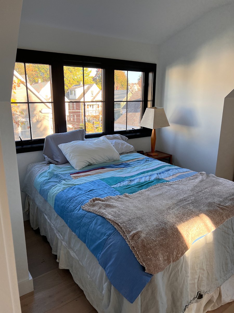 Queen bed and bright windows in rental room