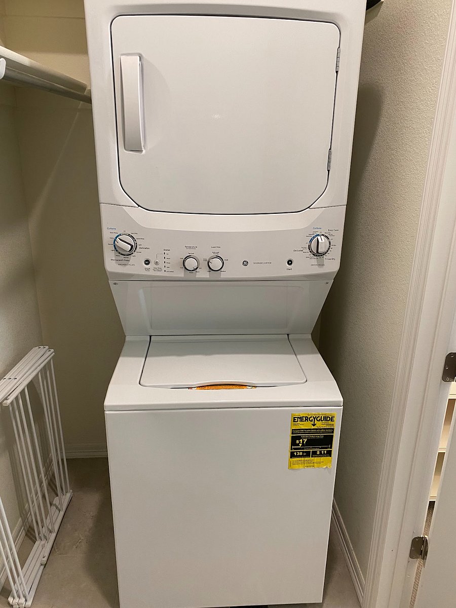 Stacked washer and dryer located off bedroom for private use.