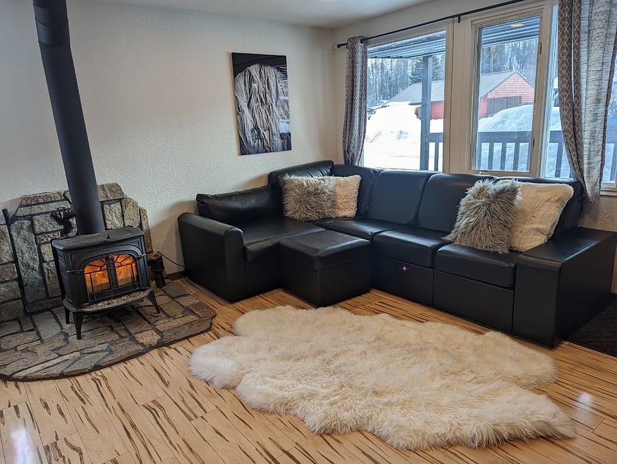 living room with faux leather couch. Extra blankets are stored beneath the cushions.
