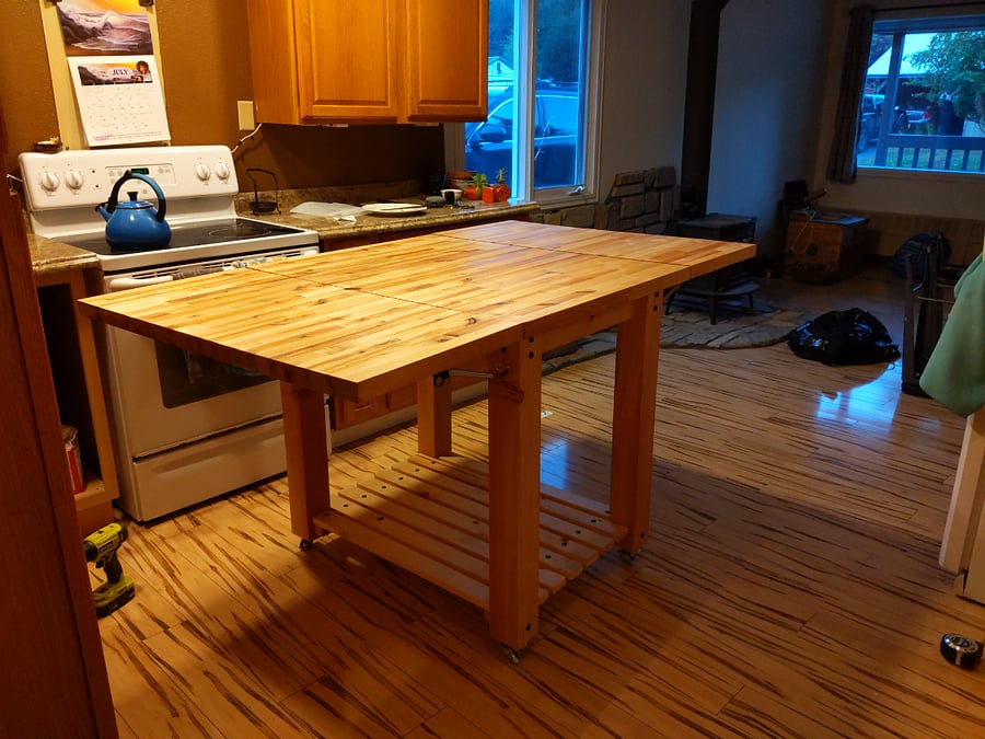 Kitchen island has wheels, 2 folding leaves, and storage for 2 stools inside