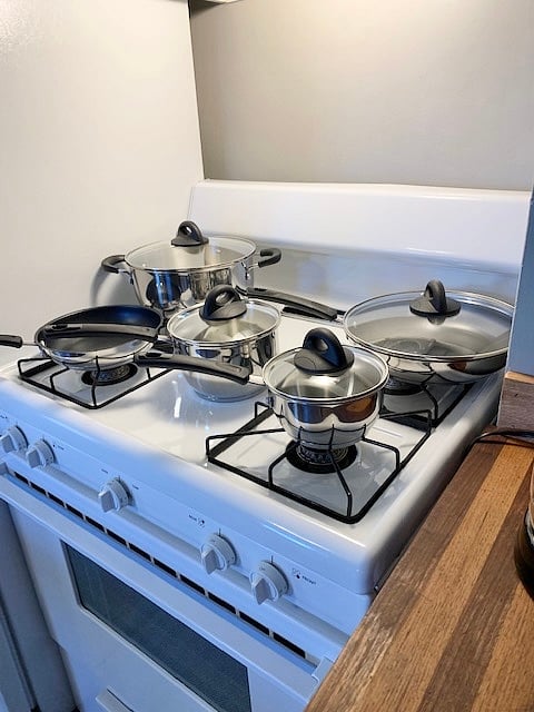 Brand NEW set of pots and pans on the gleaming gas range.