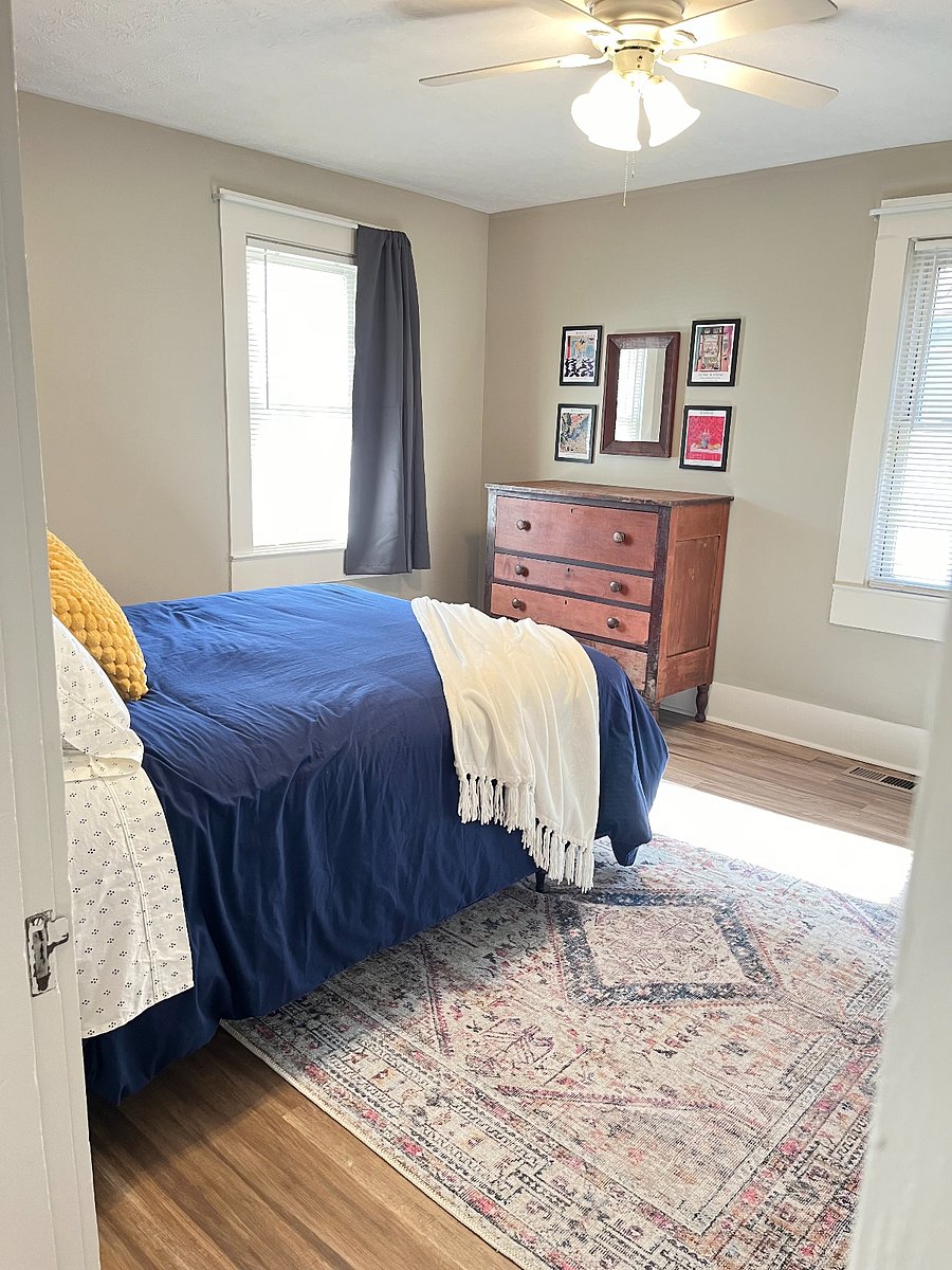 Front bedroom with queen bed and full blackout curtains for daytime sleeping.