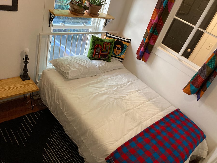 second bedroom with closet, blackout blinds on french doors and window, full size bed.