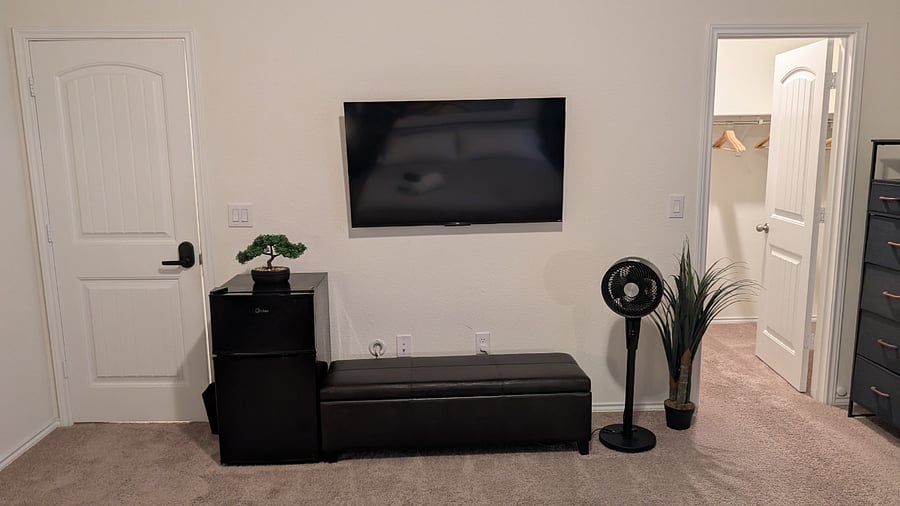 Primary suite with Smart TV, mini-fridge, and dresser storage