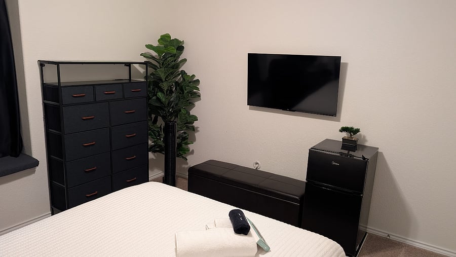 Smart TV, mini-fridge, closet, and storage in the upstairs first queen bedroom