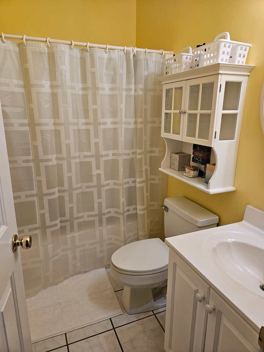 Behind the shower curtain is a standard size bath with a shower. 