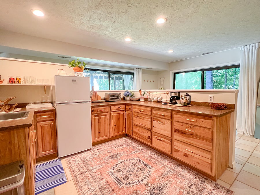 Kitchen is well-equipped with plenty of items for cooking and storage for food.