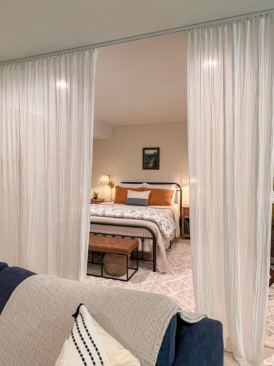 View from the living room into the bedroom with curtains partially closed.