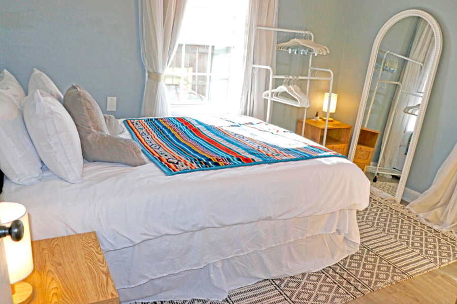 Queen size bed & floor standing mirror feature in this bedroom.