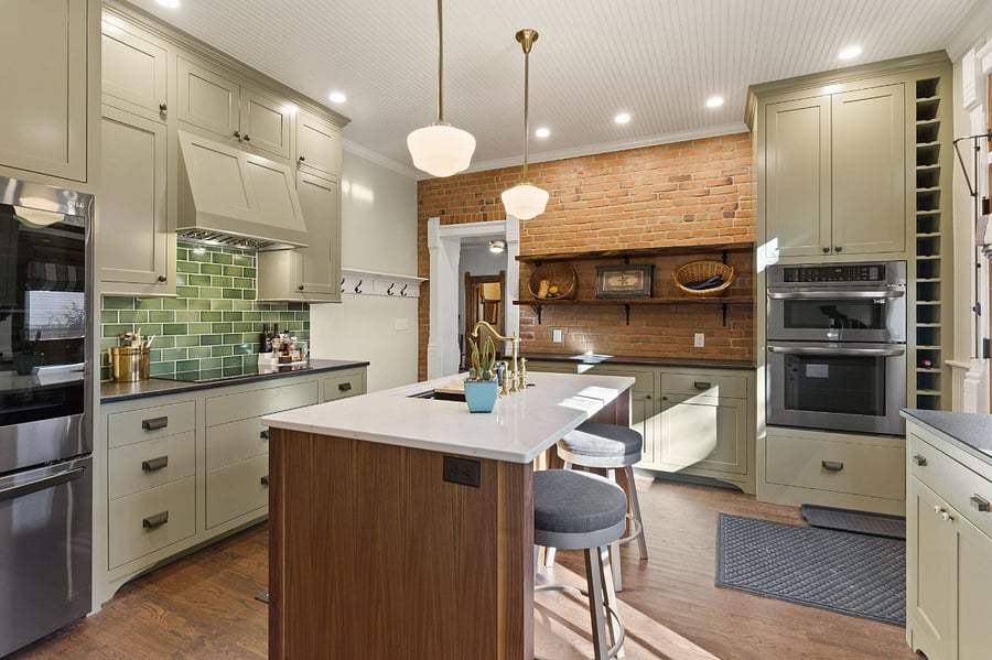 Luxury kitchen with built-in cabinets, double ovens, range hood and pantry.