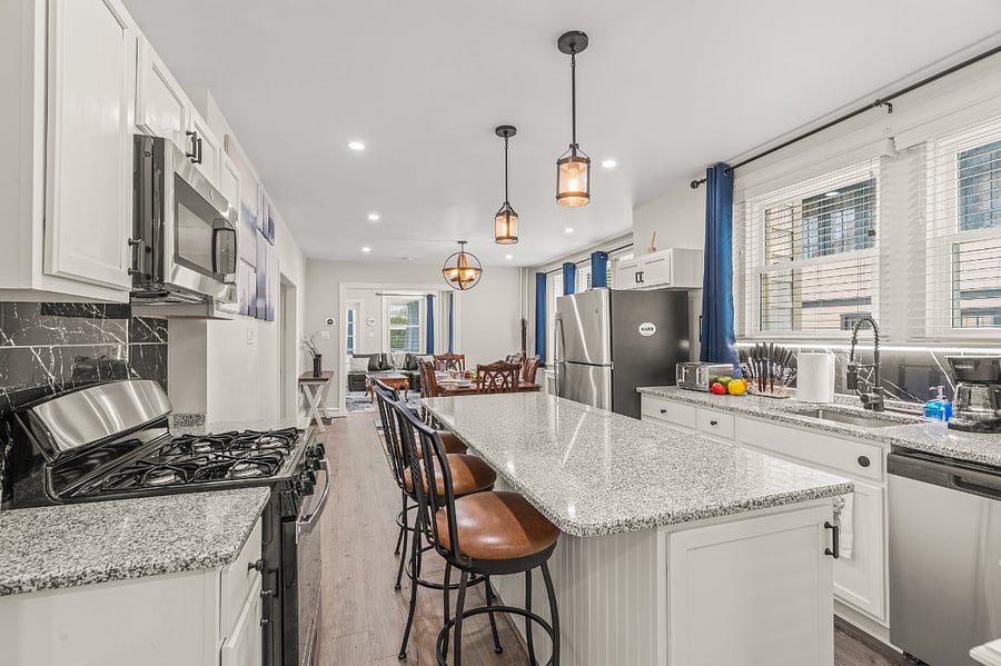 Bright, open kitchen connects from back porch mud room into dining room and living room.