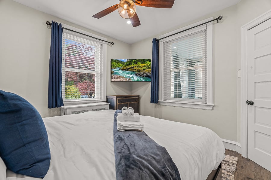 TVs in each bedroom with scenic views, storage and aesthetic themes. Views from this front bedroom of nature in Narberth with trees, shrubs and flowers - a symphony of colors - sooth the eyes. Charming houses too. Which bedroom will you choose? 