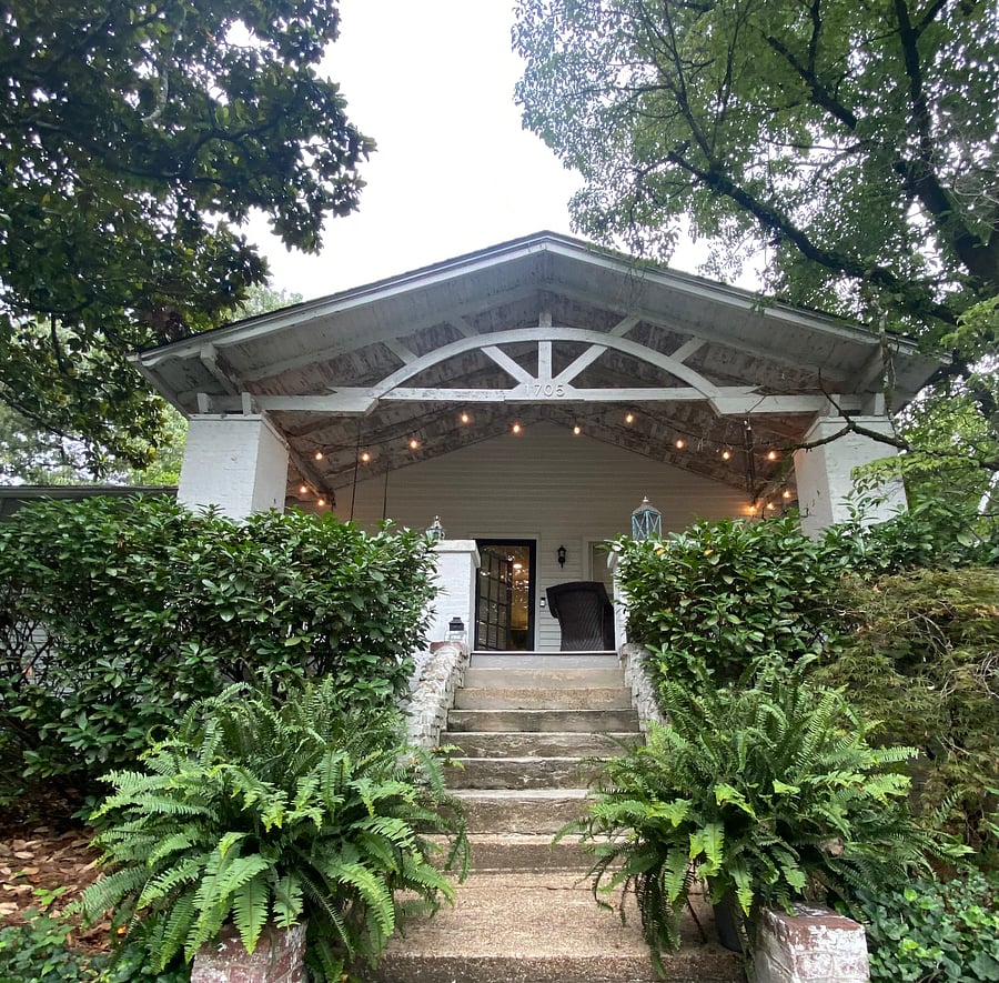 Original "Sunrise" front porch furnished and has string lights
