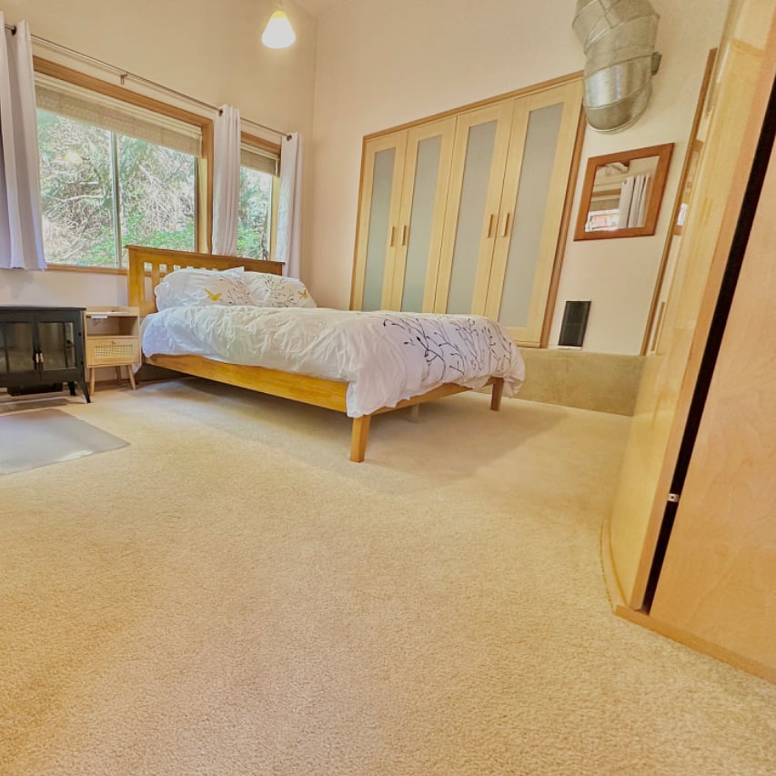 Bedroom with spacious reach-in closet, queen sized bed, entertainment center