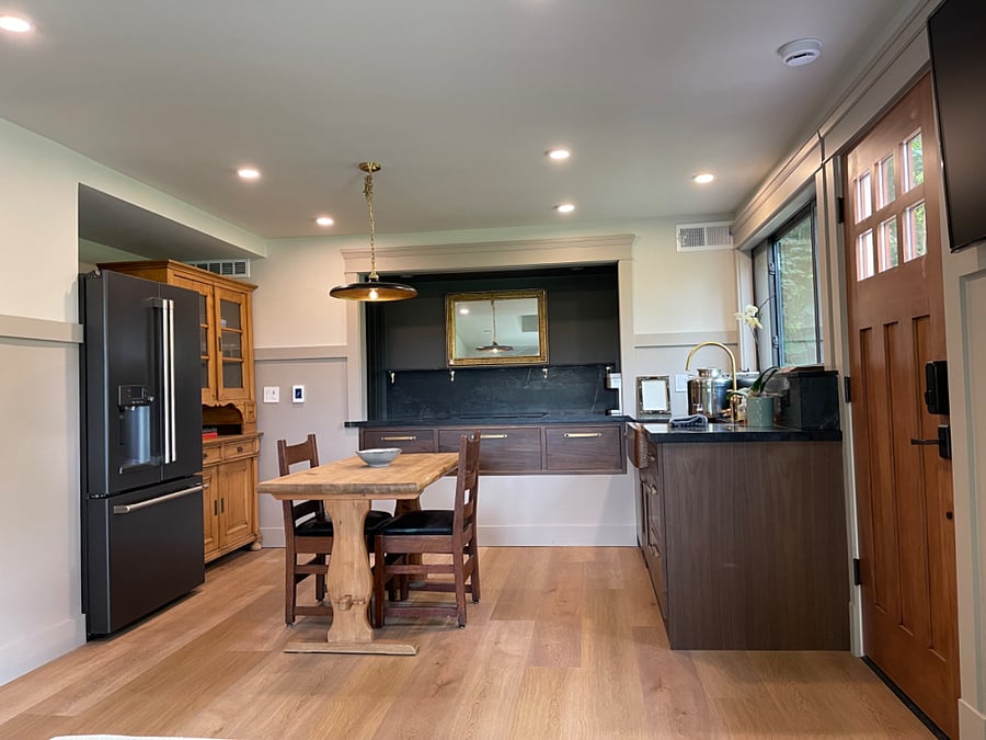 Downstairs kitchenette has full size fridge, copper sink with brass faucet, soapstone countertops, induction cooktop and custom maple cabinets. Antique pine cabinet and table/chairs.
