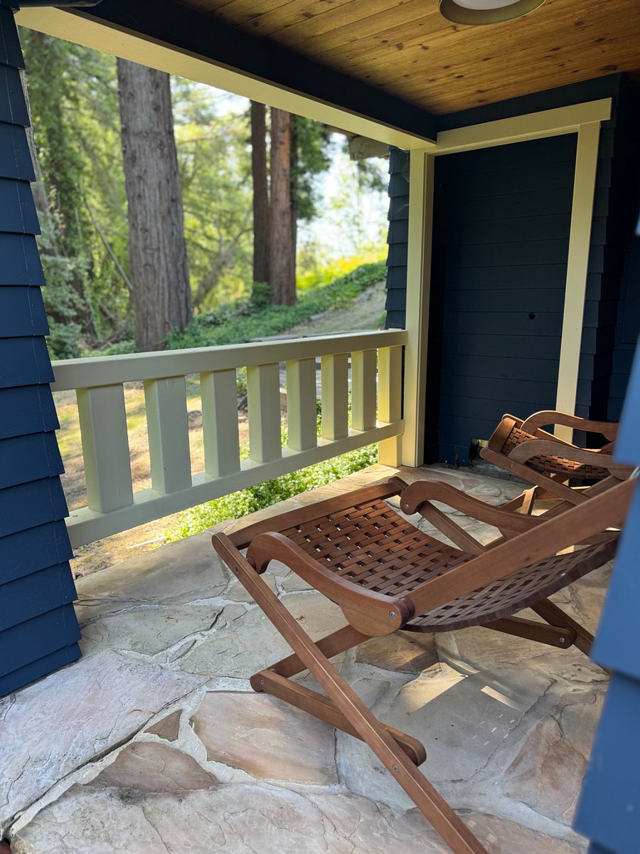 Wrap around porch off downstairs primary suite with views of redwoods and stairs to lawn.