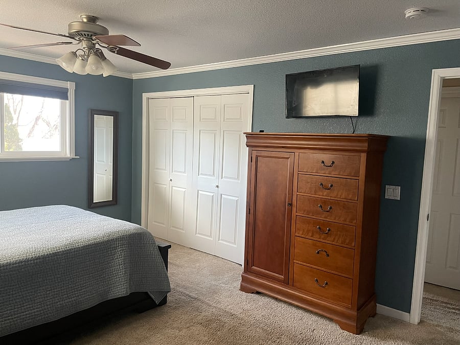 Bedroom 1: Primary Bedroom with full-length mirror, dresser, Smart TV, and closet (second closet in ensuite bathroom).