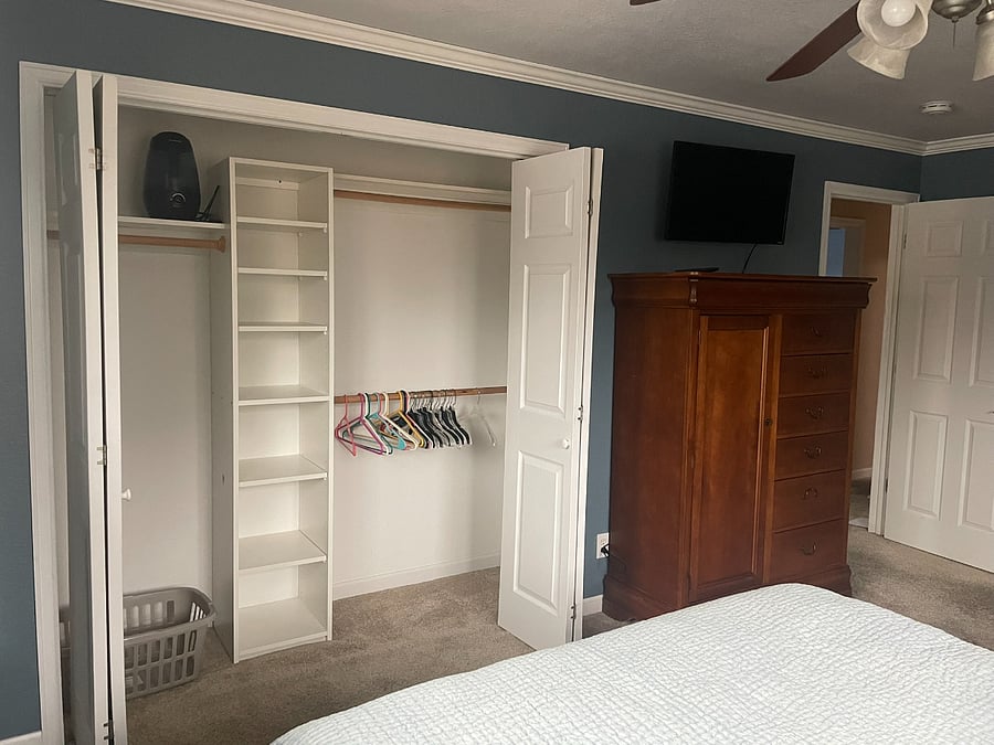 Bedroom 1: Primary Bedroom with closet (second closet in ensuite bathroom), dresser, and Smart TV.