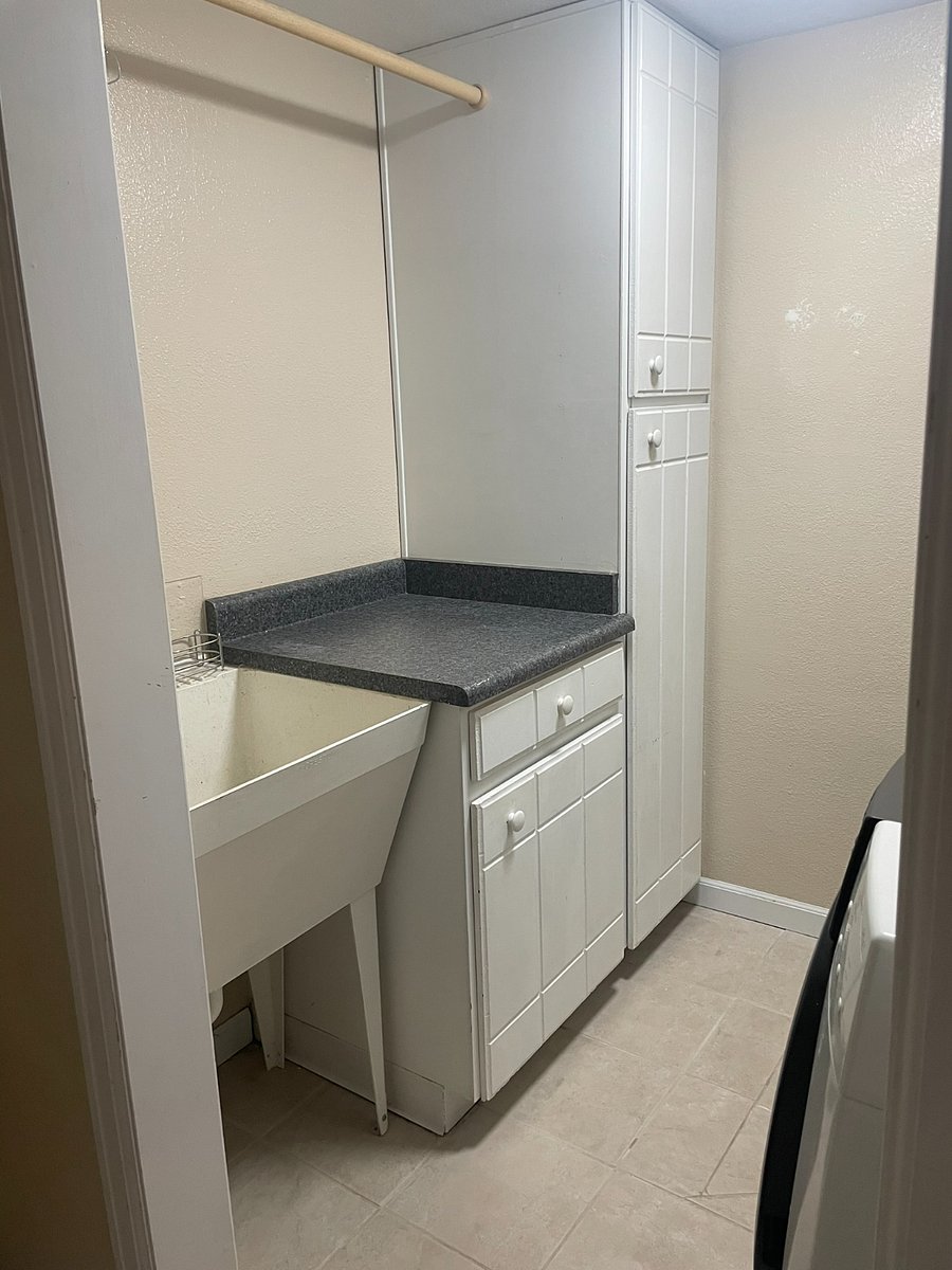 Laundry room with washer, dryer, utility sink, and storage
