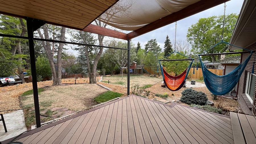 The back yard is a large, peaceful area where you can relax on the deck in the hammock chairs or work remotely at the outdoor table while listening to a variety of bird calls and songs.