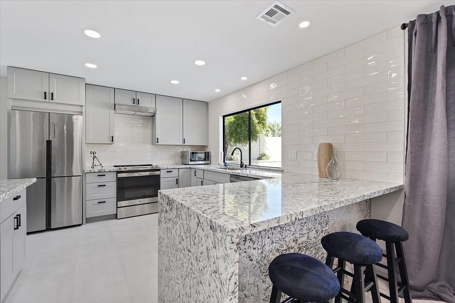 Waterfall granite kitchen with views to backyard. 