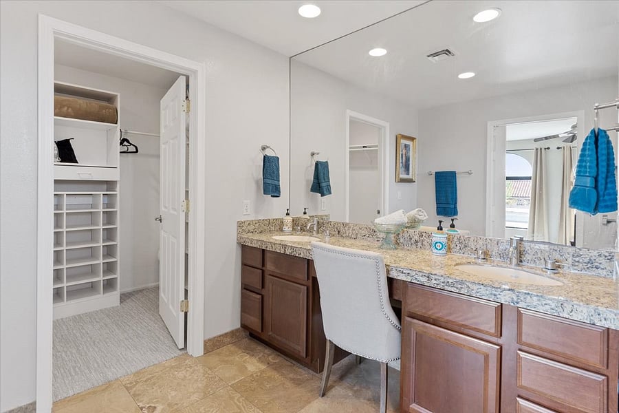 Primary private bathroom with walk in shower, two sinks, vanity and large walk in shower.