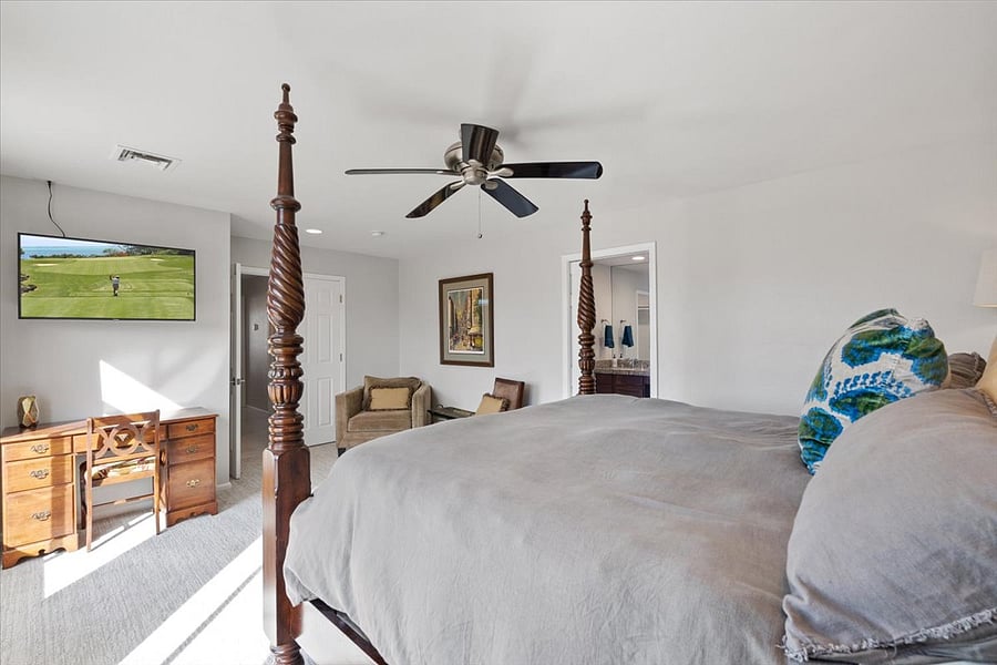 Primary bedroom with King size bed with sitting area, designated desk with 50" TV. 