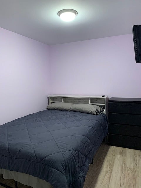 Queen sized bed, alarm, dresser, and television. Standard sized closet.