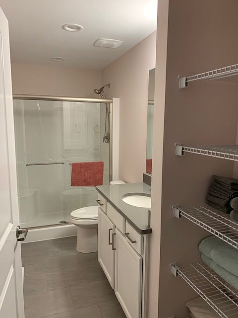 Nice size restroom with walk-in shower and soft-close toilet seat lid.