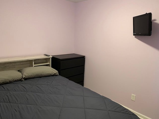 Queen sized bed, alarm, dresser, and television.
Standard sized closet.
