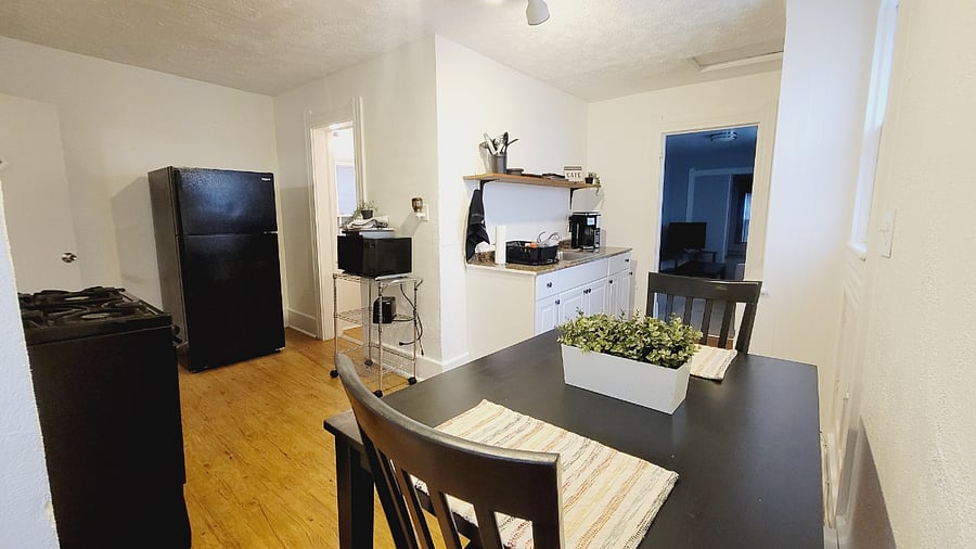 This lovely kitchen has a fridge, gas stove, and cabinet space for food and dishes. There's also a shelf above the sink area to add extra things. There's a ninja coffee maker and dish rack to dry dishes. Under the sink is a first aid kit, extra light bulbs, fire extinguishers, and more. Also, there's a microwave cart with a microwave and toaster. There's silverware, cups, and plates as well.