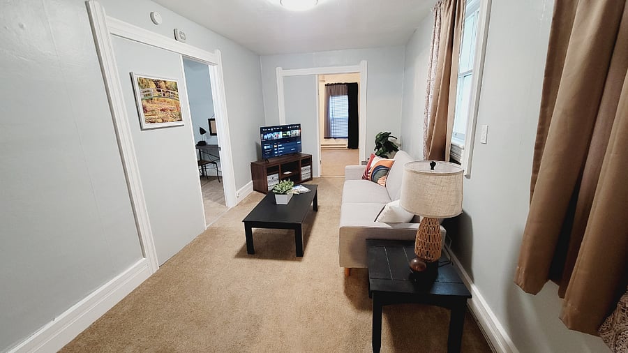 Living room with a futon for extra sleeping. Also,  has a smart tv for streaming. 