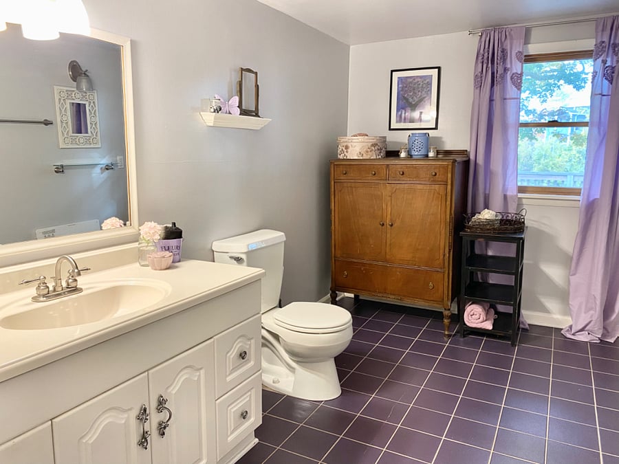 Large full bathroom with plenty of space, full bathtub and ironing board.