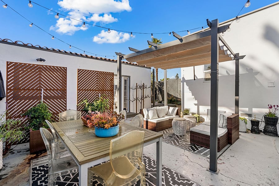Outdoor space with a table, outdoor couch, and a bbq.