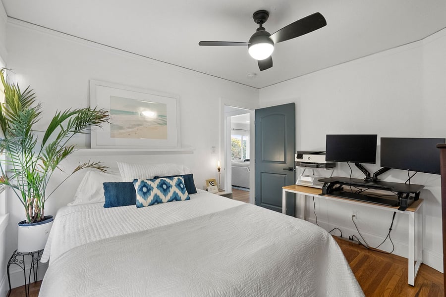 Bedroom #3 has a queen-sized bed in it and a work-from-home work space with two monitors