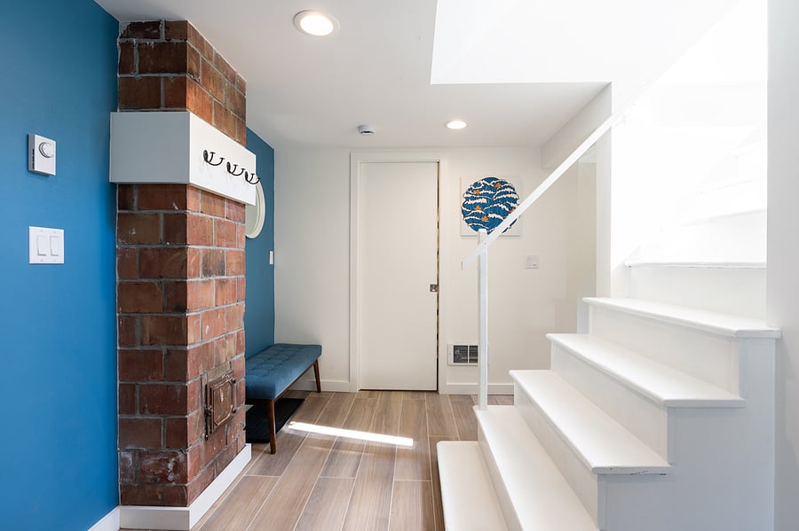 Entryway with hooks and rubber mat for shoes. Bench for place to sit to tie your shoes.