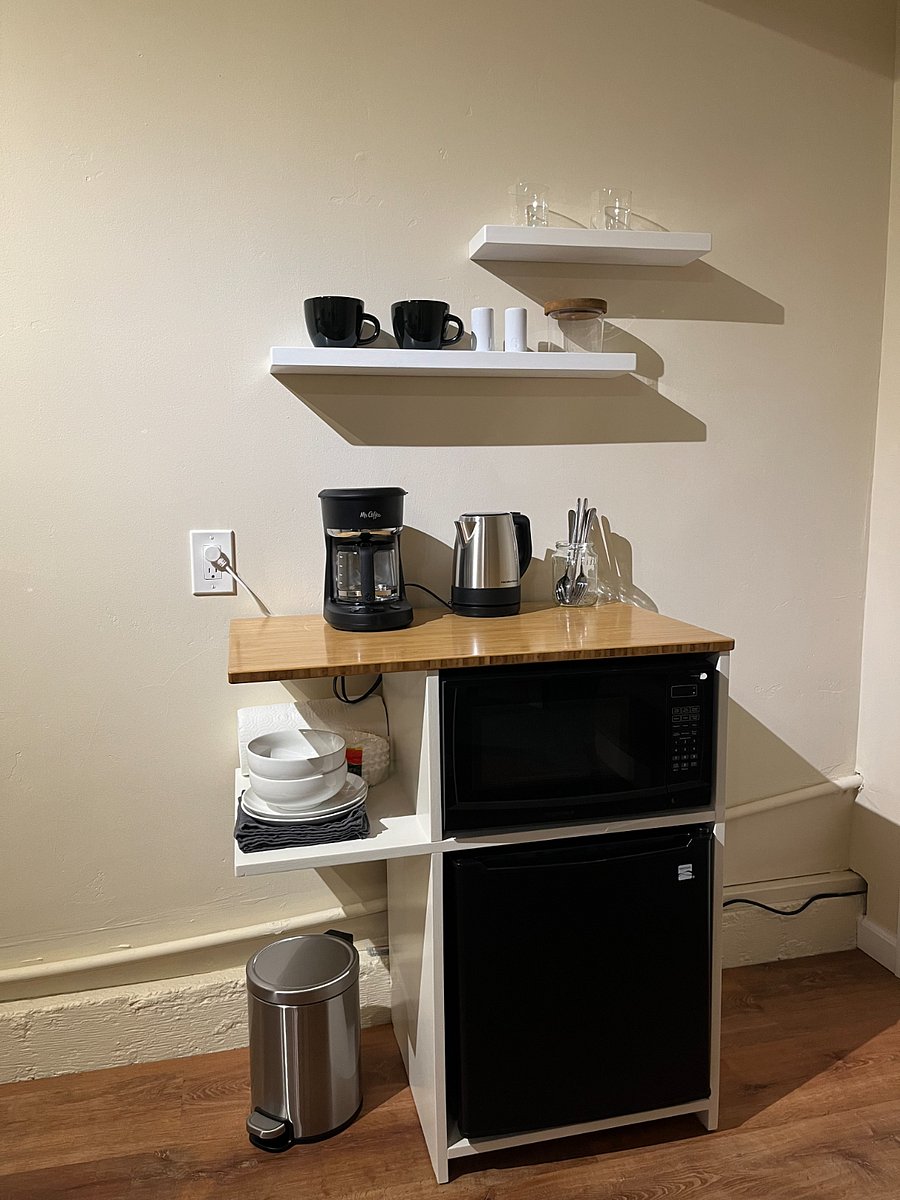 Mini kitchen area with: mini fridge, microwave, drip coffee, electric kettle.