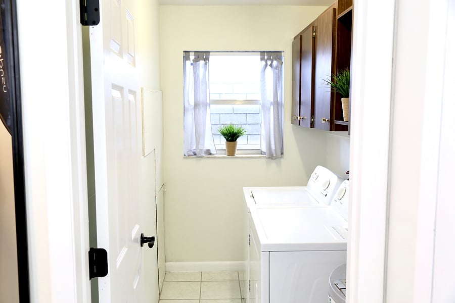 In unit washer and dryer with overhead cabinet storage