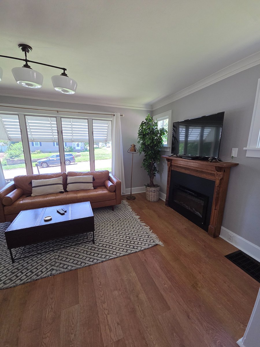 Large TV w/ Firestick, decorative fireplace, and full length curtains cover entire window area for privacy.