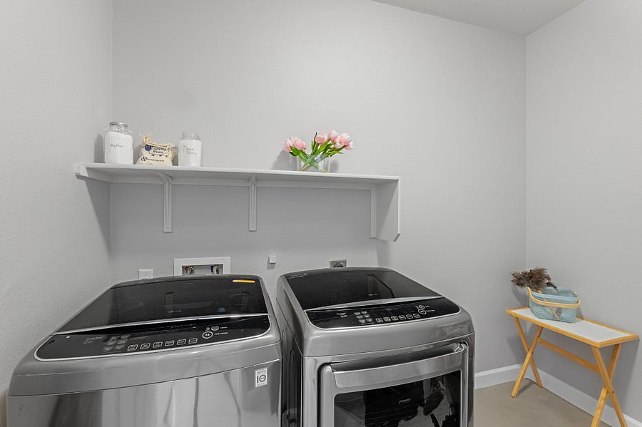 Laundry room with washer and dryer in-house.