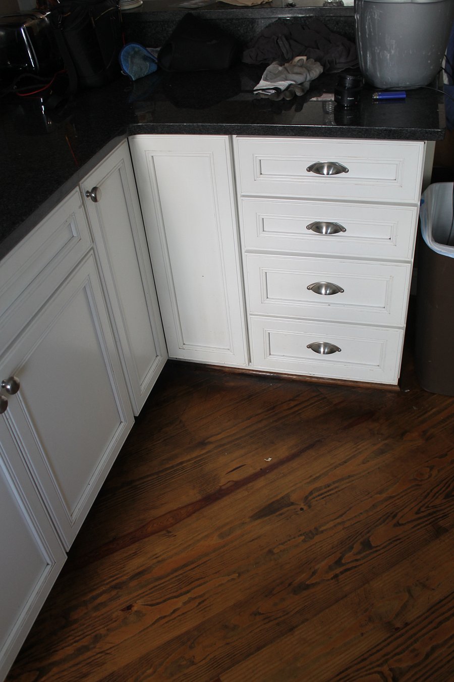 Corner cabinets with pots, pans, and bowls for use. 