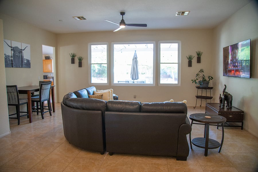 The Living Room is set up with a high-top seating area and a large sectional.  Great view into the enormous back yard.
