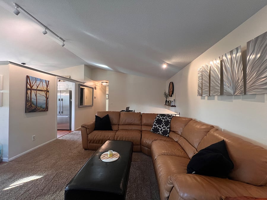 Upstairs living room. Vaulted ceilings. Large smart TV. Electric fire feature. Tons of natural light through brand new windows.