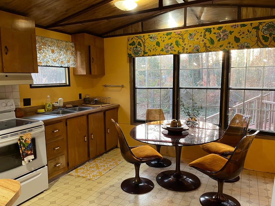 A basic open floor plan kitchen with lots of counter space. Vintage mid-century glass table and tulip chairs...